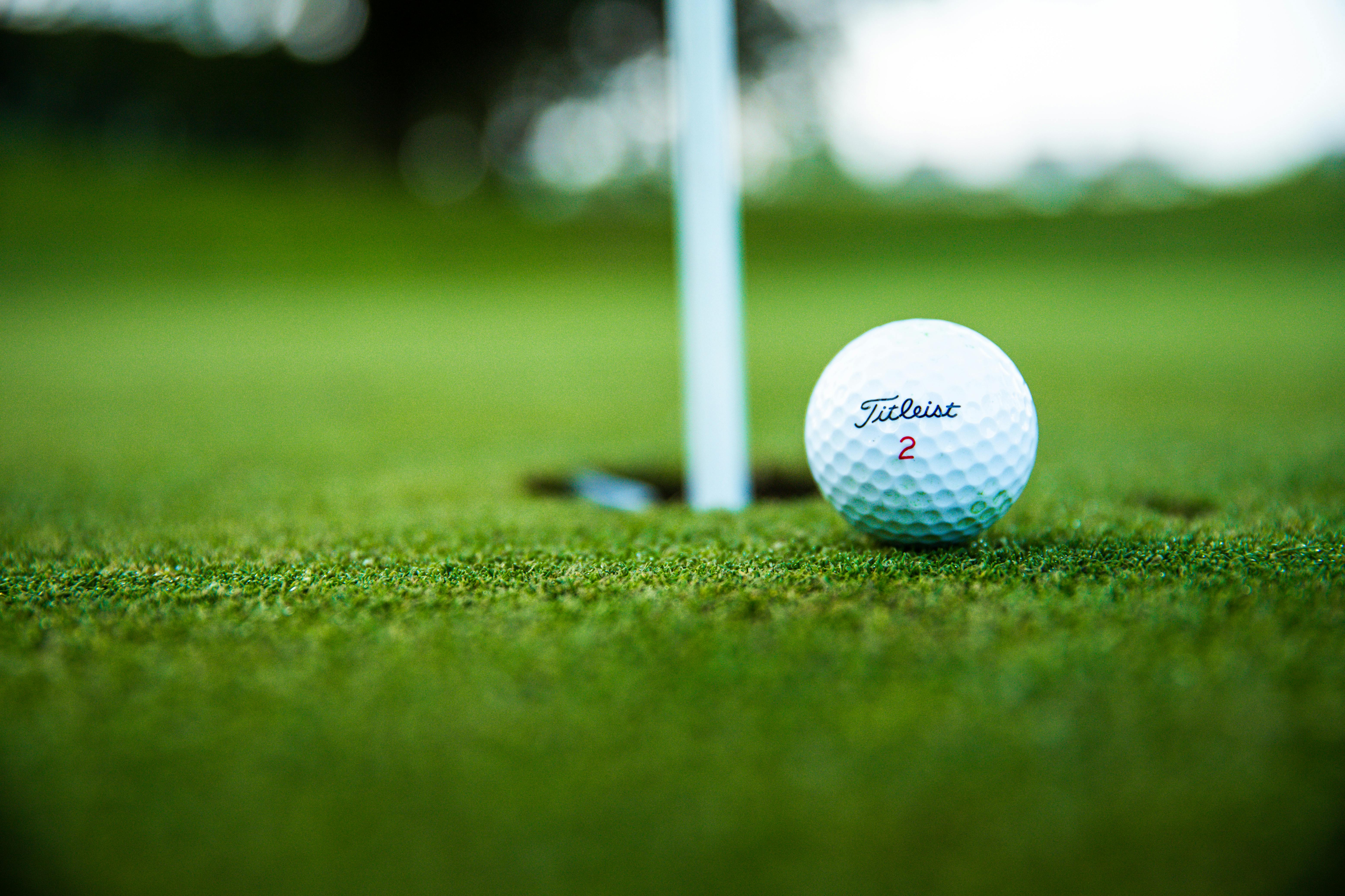 Image of golf ball on tee on grass.